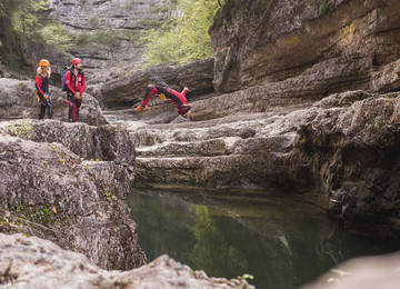 Ein Mann springt beim Canyoning in Salzburg ins Wasser