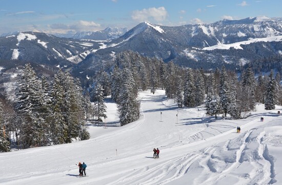 Ein Paar mit Skiausrüstung beim Skiurlaub im Salzkammergut