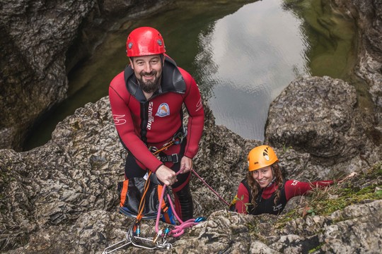 Beim Canyoning in Salzburg lachen der Führer und eine junge Frau in die Kamera