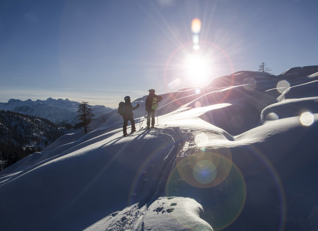 eine Familie beim Schlittenfahren im Aktivurlaub im Salzkammergut