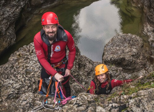 Ein Man uns eine Frau lachen beim Canyoning im Salzkammergut in die Kamera