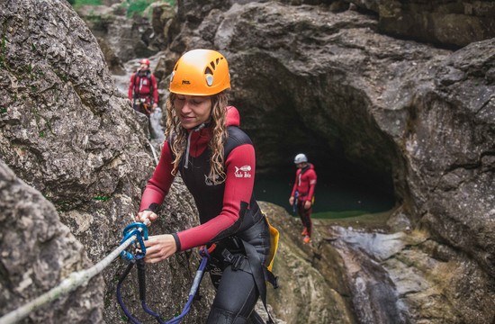 Eine Frau überprüft die Sicherung beim Canyoning in Salzburg