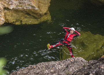 Ein Mann treibt beim Canyoning in Salzburg genüsslich im Wasser