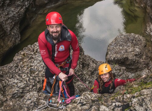 Ein Man uns eine Frau lachen beim Canyoning im Salzkammergut in die Kamera
